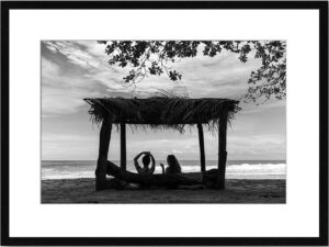 Photo de paysage de mer en tirage limité en noir et blanc. bord de mer avec 2 jeunes filles sous une paillote en contre jour. Michèle Gabet Photographie