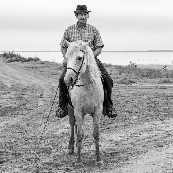 Photo en tirage limité en noir et blanc. Série chevaux de camargue de Michèle Gabet Photographie. Portrait de gardian et son cheval