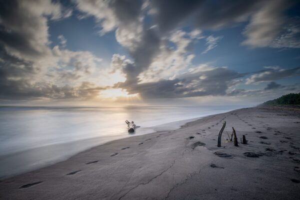 Photo de paysage en tirage limité. plage au costa rica avec un bois flotté échoué sur le sable. pose longue. Michèle Gabet Photographie