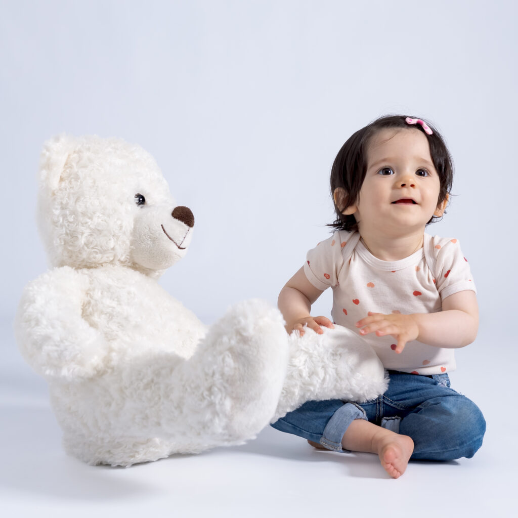 photo de grand bébé avec un ourson blanc au studio.