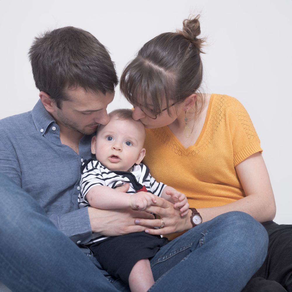 photo de bébé dans les bras de ses parents au studio